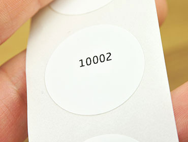 Image of a circle white NFC tag with a black ID print